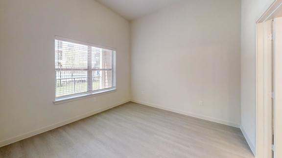 A room with a window and wooden flooring.