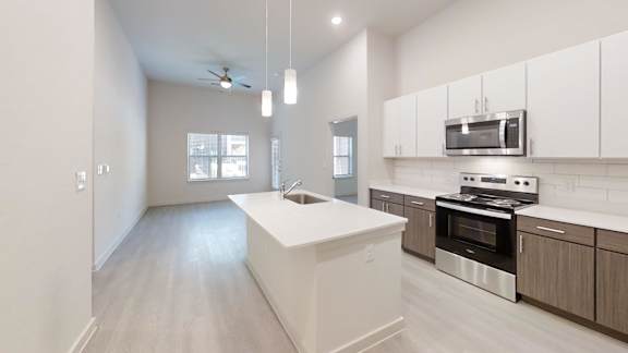 A modern kitchen with a white island and stainless steel appliances.