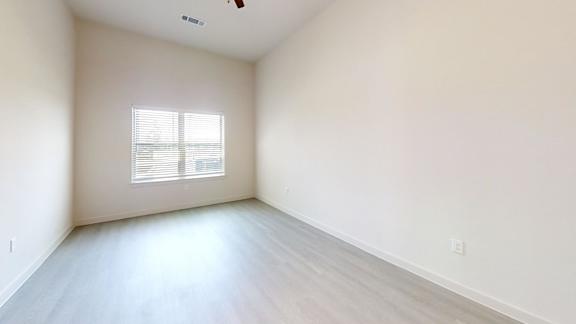 A room with a window and a ceiling fan.