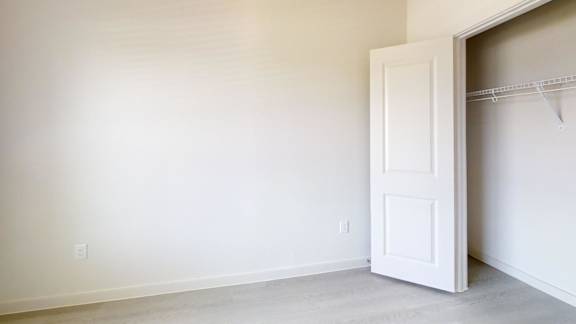 A white door is open in a room with white walls.