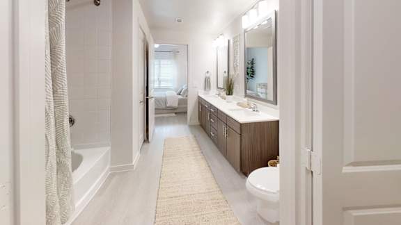 A bathroom with a white tub, sink, and toilet.
