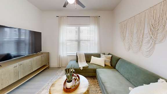 A living room with a green couch and a wooden coffee table.