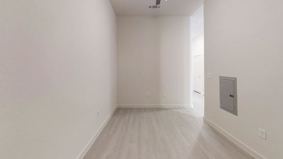 A room with a white wall and a door on the right side.