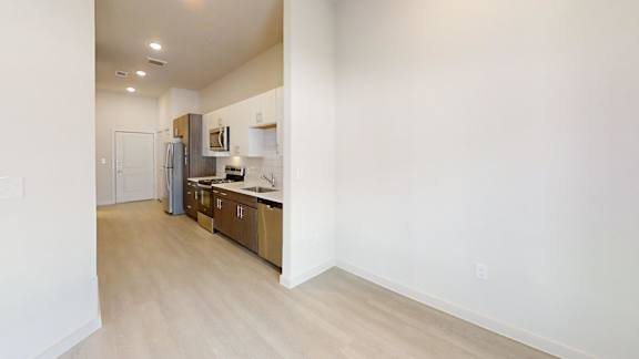 A kitchen with white cabinets and a refrigerator.