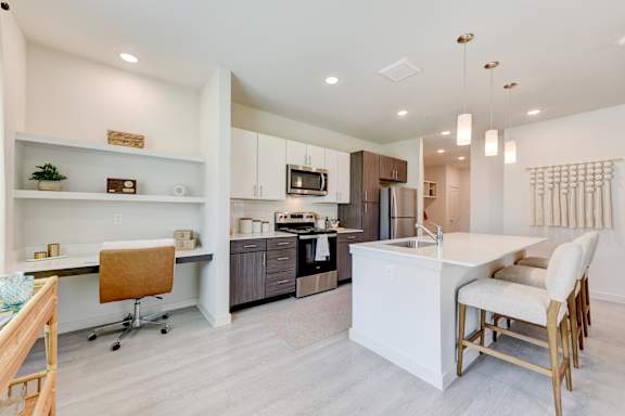 Open concept kitchen with work nook and island seating at Cantarra Apartments, Texas
