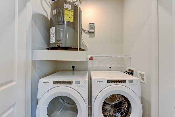 Laundry room with water heater and front load machines at Cantarra Apartments, Texas, 78653