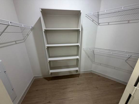Empty white shelves in a room with wooden floors.