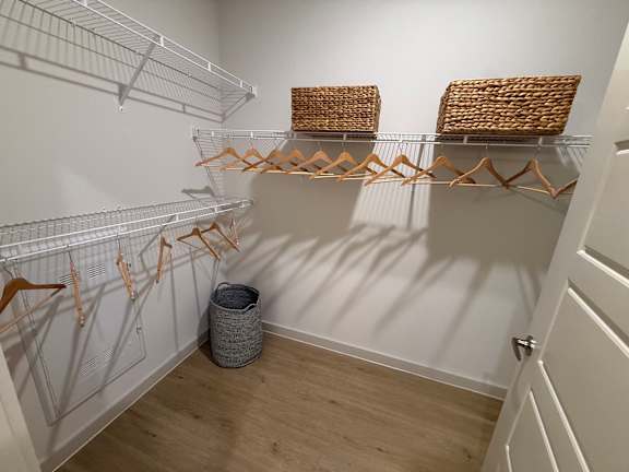 A white closet with a basket on the shelf.