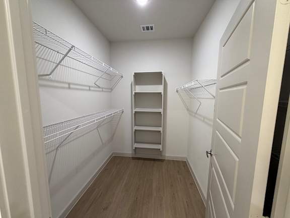 A walk-in closet with shelves and a door.