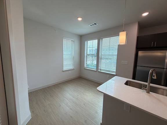 A kitchen with a sink and a window with blinds.