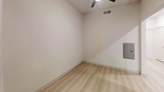 A room with a light wooden floor and a ceiling fan. at Bridge at Saffron Apartments, Austin