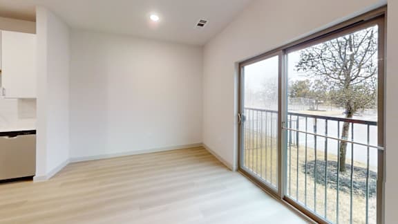 A room with a sliding glass door leading to a backyard. at Bridge at Saffron Apartments, Austin, TX, 78717