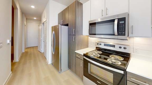 A kitchen with a stove, microwave, and refrigerator.