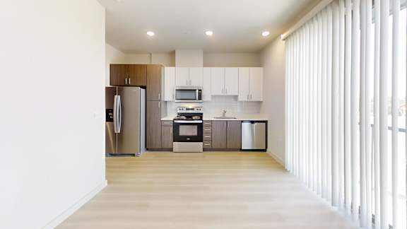 A kitchen with white cabinets and a refrigerator.