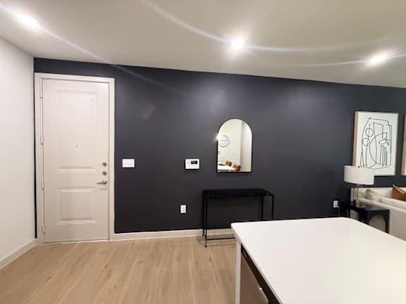 A room with a white door and a black table.