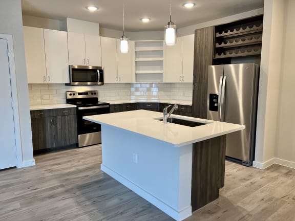 a kitchen with white cabinets and a large island