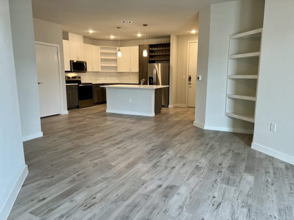 a kitchen and living room with a wooden floor