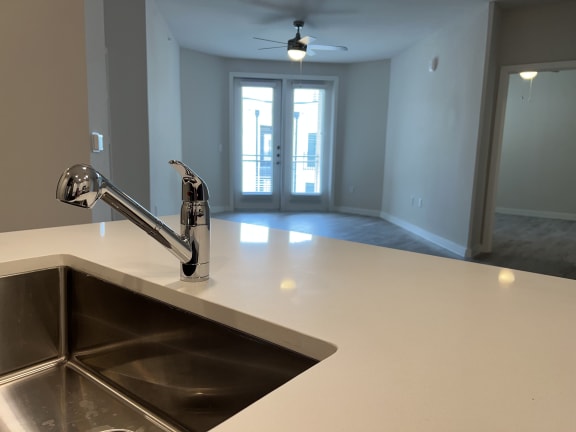 a kitchen with a sink and a ceiling fan