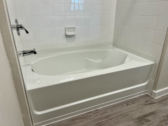 a large white bathtub in a bathroom
