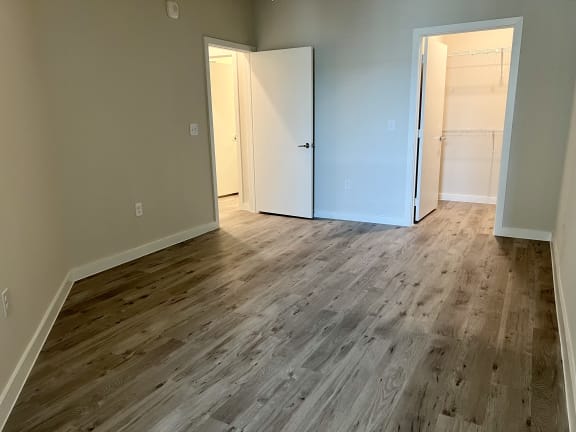 a bedroom with hardwood floors and grey walls