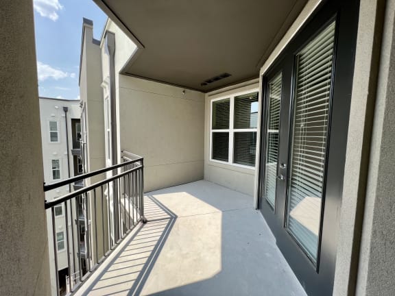 a balcony with a large window and a door