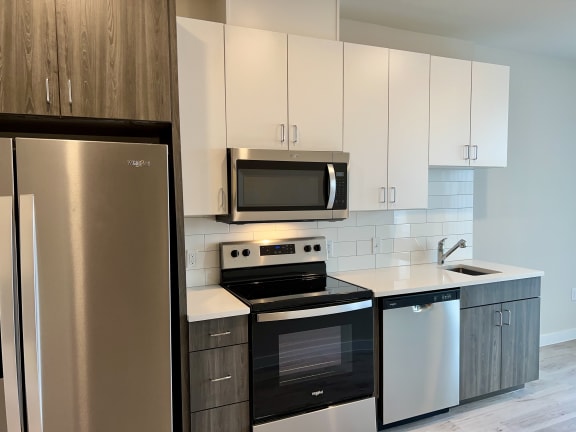 a kitchen with white cabinets and stainless steel appliances