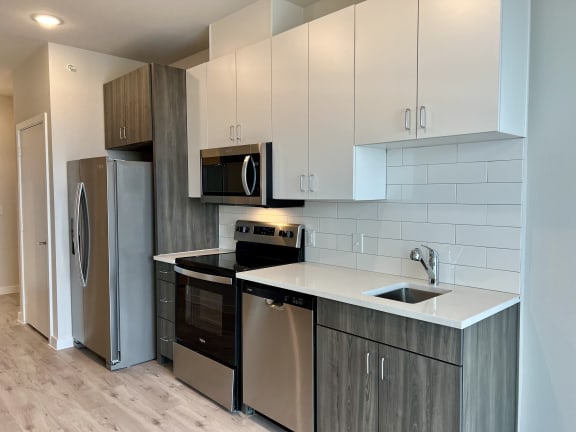 a kitchen with white countertops and stainless steel appliances