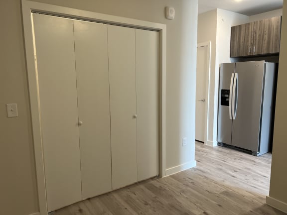 a bedroom with a large closet and a refrigerator