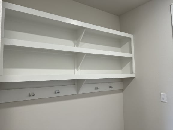 an empty shelf in the corner of a room