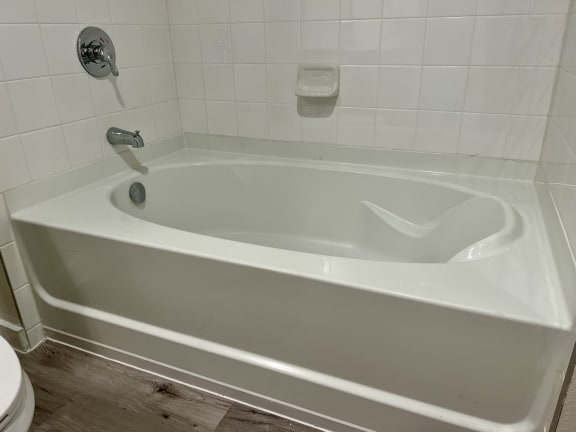 a white bathtub in a white bathroom