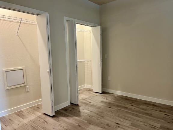 a bedroom with hardwood floors and grey walls