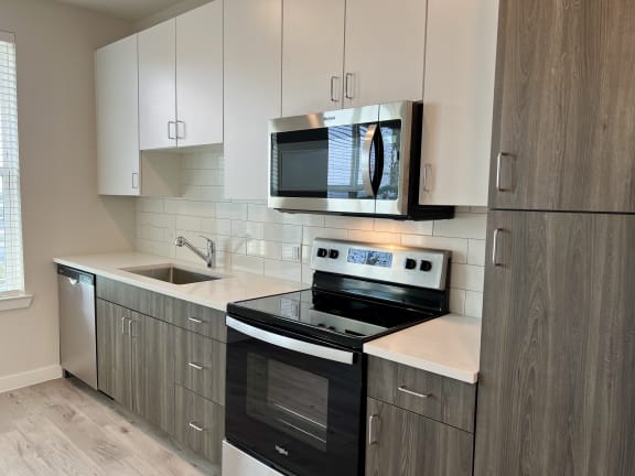 a kitchen with white cabinets and black appliances