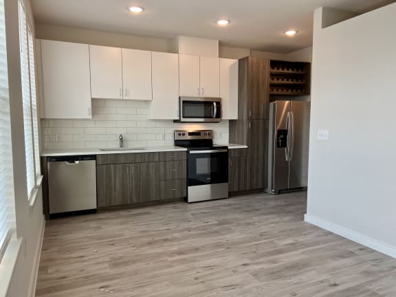 a kitchen with white cabinets and black and white appliances
