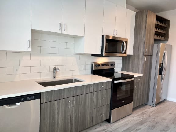 a kitchen with white cabinets and stainless steel appliances
