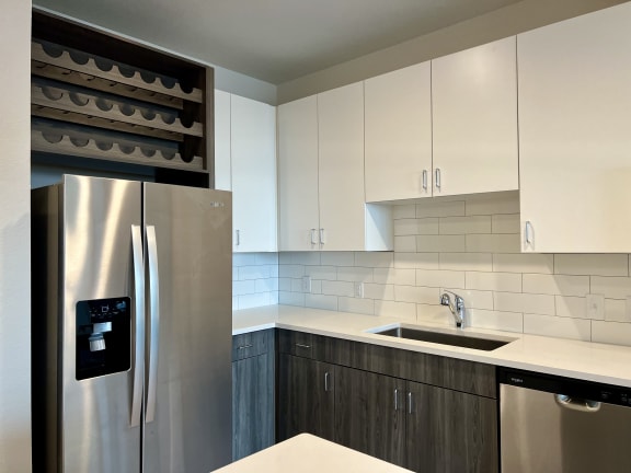 Kitchen with wine storage above stainless refrigerator at Bridge at Windsor Park Apartments, Texas