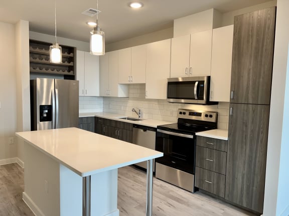 Kitchen with white upper cabinets and wood grain base at Bridge at Windsor Park Apartments, Texas, 78723