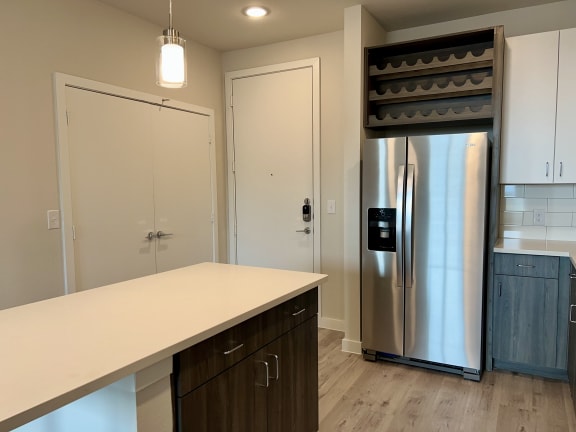 Kitchen island with wine storage above refrigerator at Bridge at Windsor Park Apartments, Austin, TX 78723