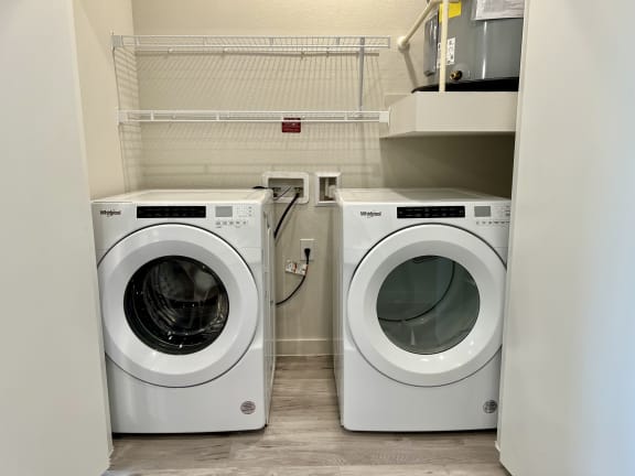 Front loading washer and dryer with overhead shelving at Bridge at Windsor Park Apartments, Austin, 78723