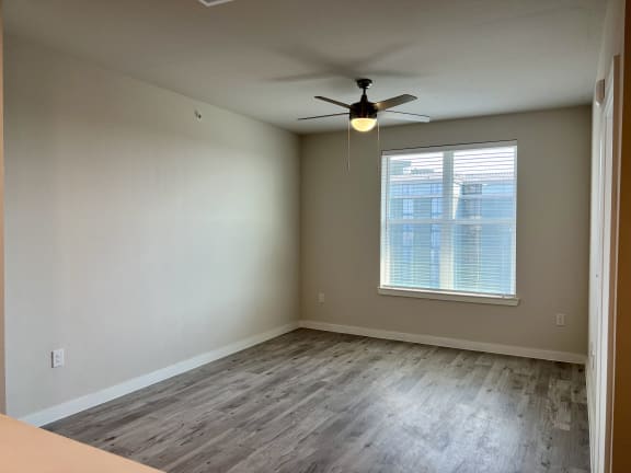 Vacant bedroom with window and ceiling fan light at Bridge at Windsor Park Apartments, Austin, Texas