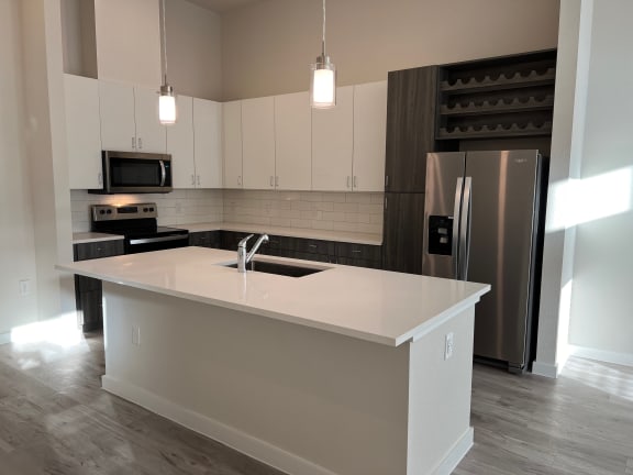 Kitchen island with pendant lights and undermount sink at Bridge at Windsor Park Apartments, Texas, 78723