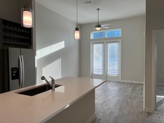 Kitchen island with pendant lights overlooking dining area at Bridge at Windsor Park Apartments, Austin, 78723