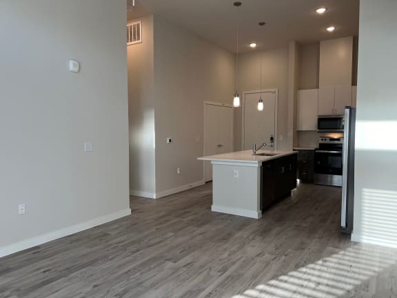 Open floor plan with kitchen peninsula and pendant lighting at Bridge at Windsor Park Apartments, Austin