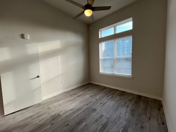 Vacant bedroom with window blinds and wood style floor at Bridge at Windsor Park Apartments, Texas, 78723