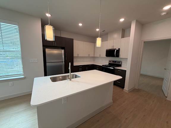 A kitchen with a white countertop and a sink.