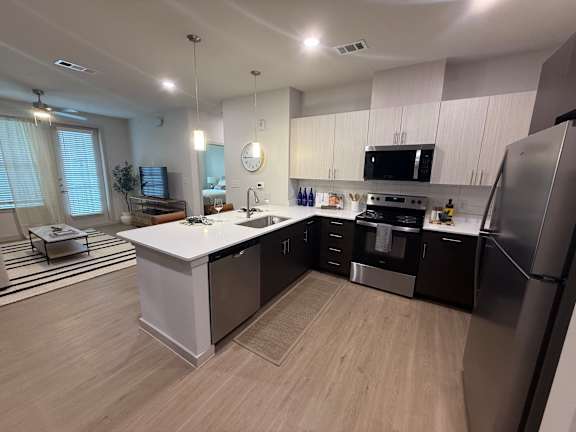 A modern kitchen with a white island and stainless steel appliances.