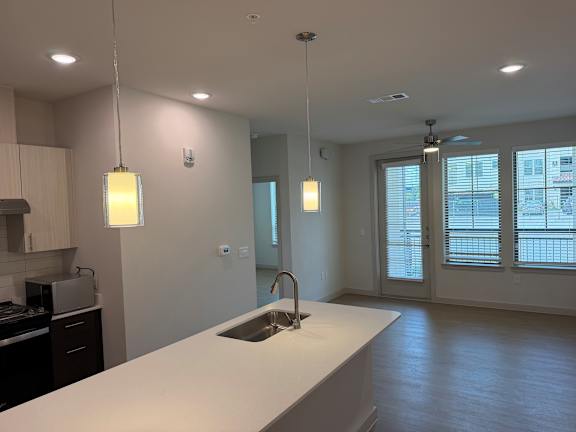 A kitchen with a white countertop and a sink.