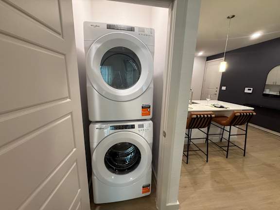 A white washing machine is in a small room.