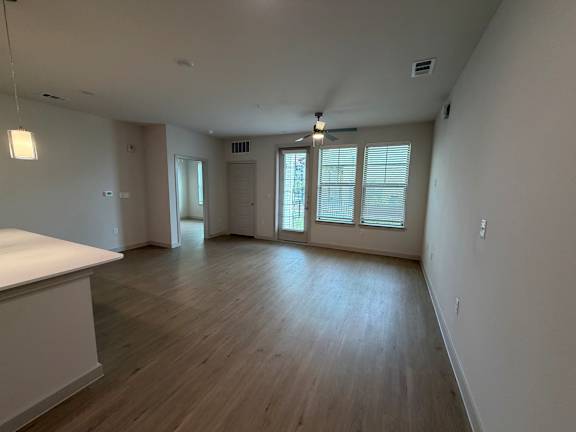 A room with wooden floors and a ceiling fan.