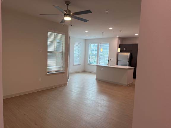 A room with a ceiling fan and wooden flooring.