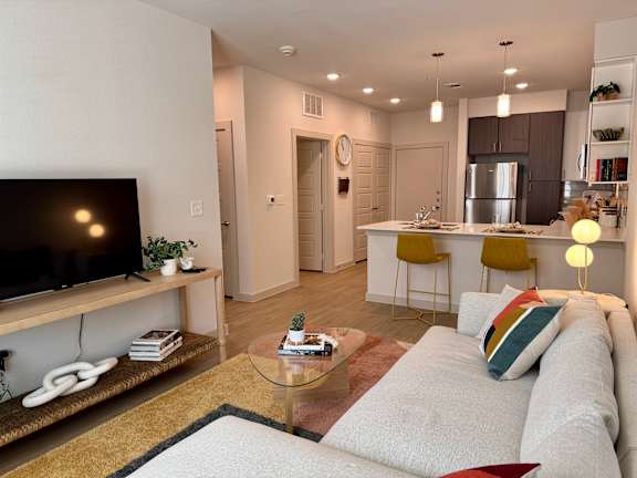 A modern living room with a flat screen TV on a wooden stand.
